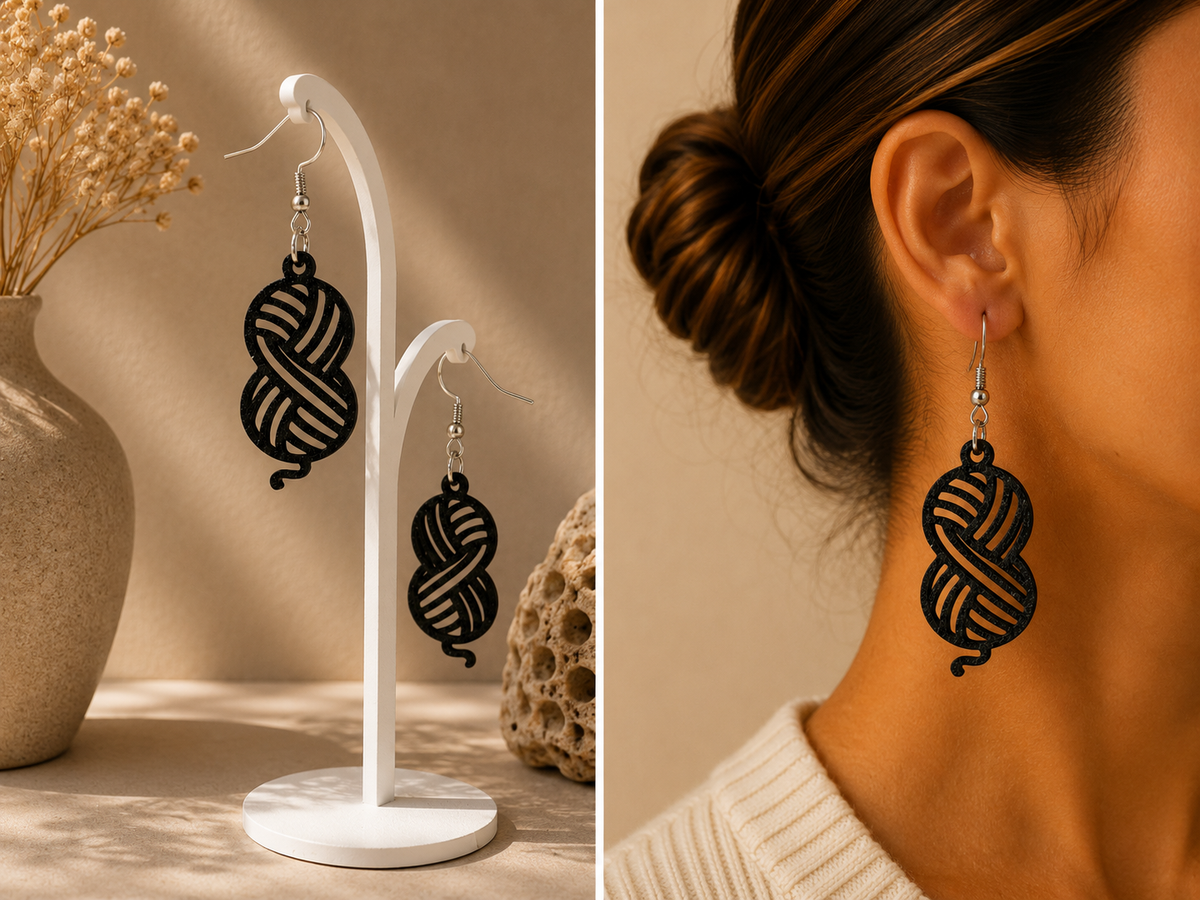 Boucles d’oreilles noires au motif de pelote de laine ajouré, présentées sur support et portées