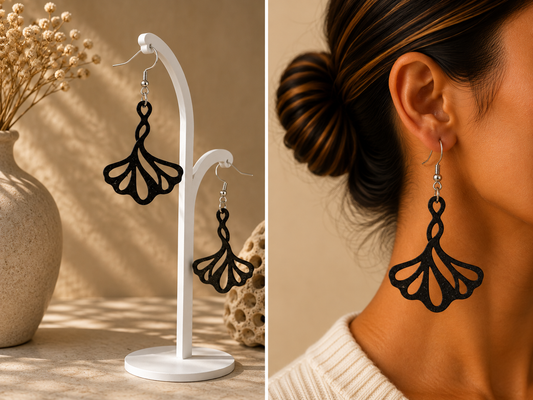 Boucles d’oreilles noires au motif de feuille de ginkgo ajourée, présentées sur support et portées