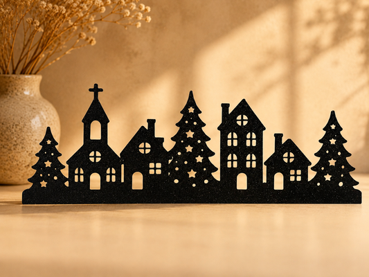 Silhouette noire d'un village de Noël avec clocher, maisons et sapins